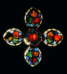 Colorful stained glass window with intricate symmetrical patterns, glowing vividly.
